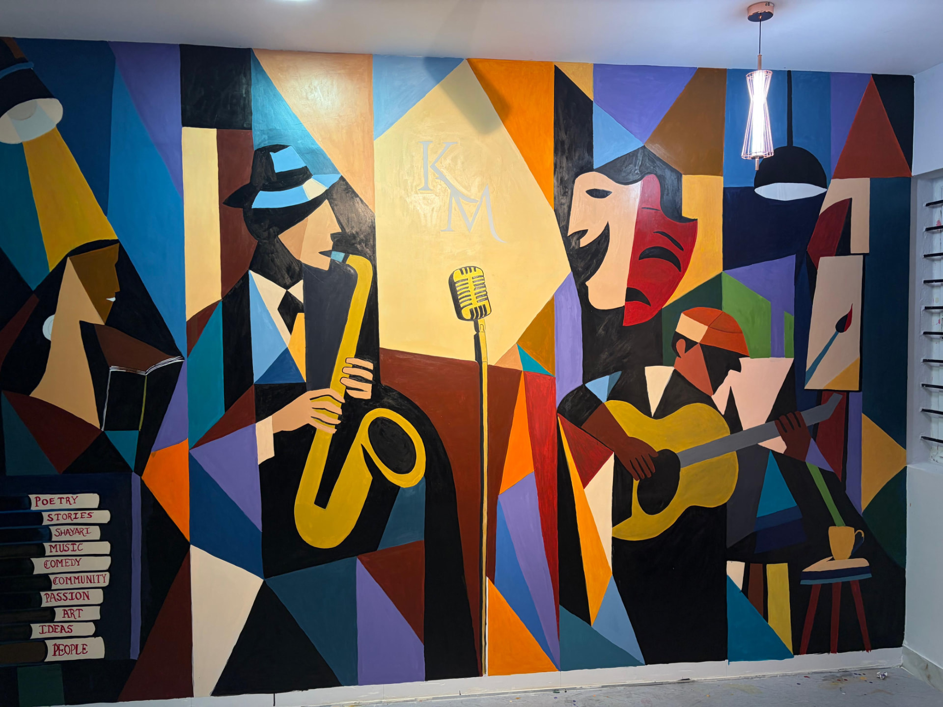 Hand-painted cubist mural at Kala Manch Studio with a saxophonist, microphone, theatre masks and guitarist